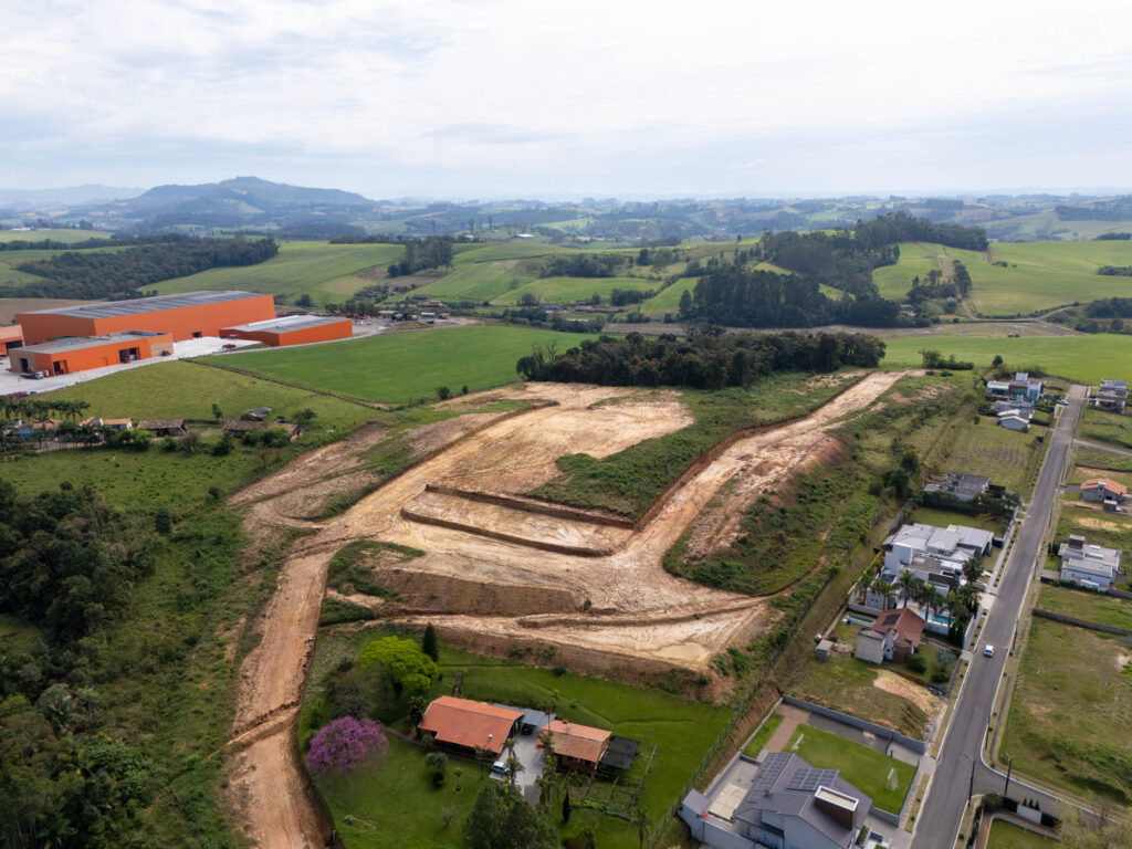 Loteamento Spatium Reviver visto de drone, com as ruas em abertura e o bairro vizinho